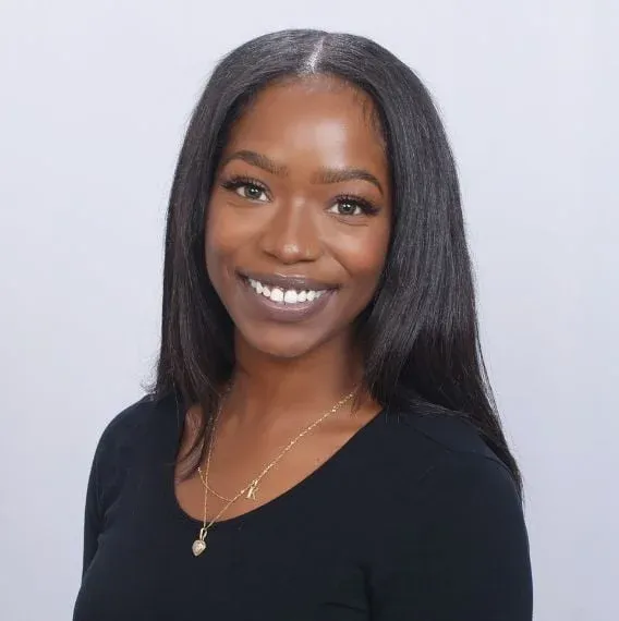 Smiling woman with long hair and necklace.