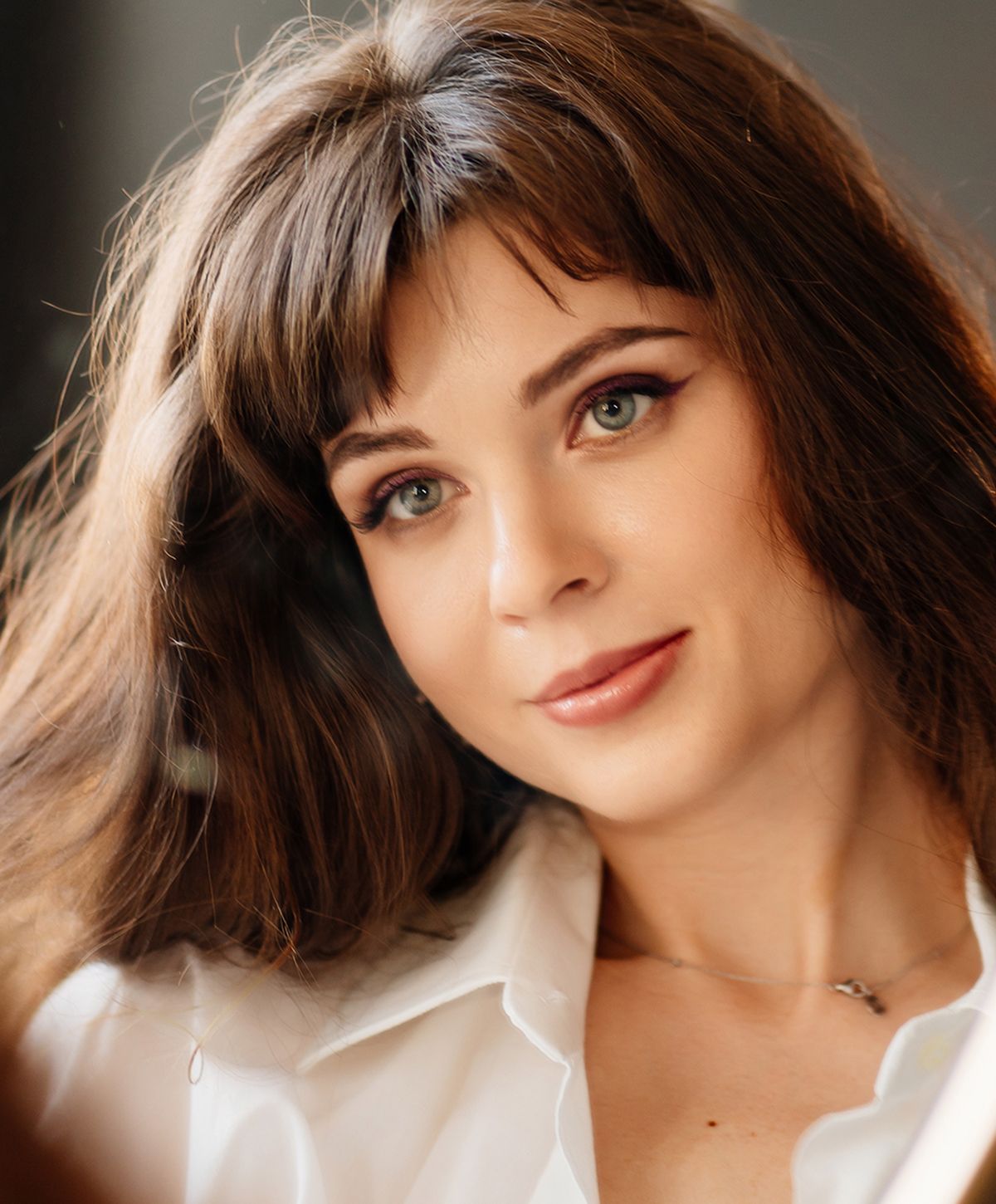 Woman with brown hair and green eyes.