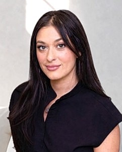 Woman with long dark hair in black top.
