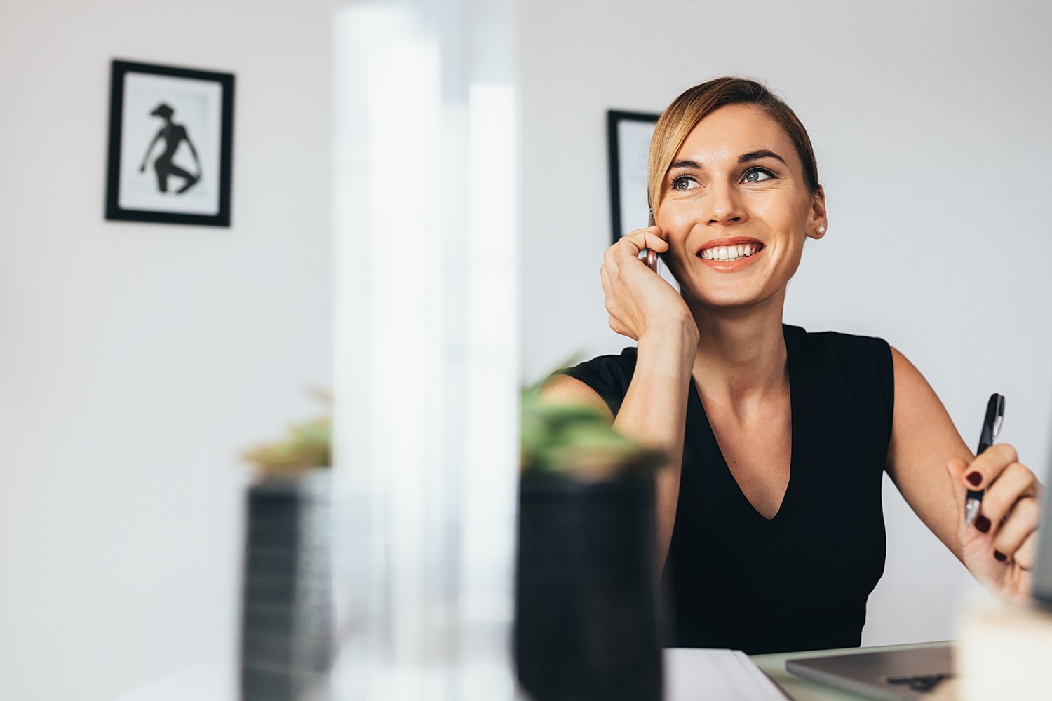 Woman smiling on the phone in an office.