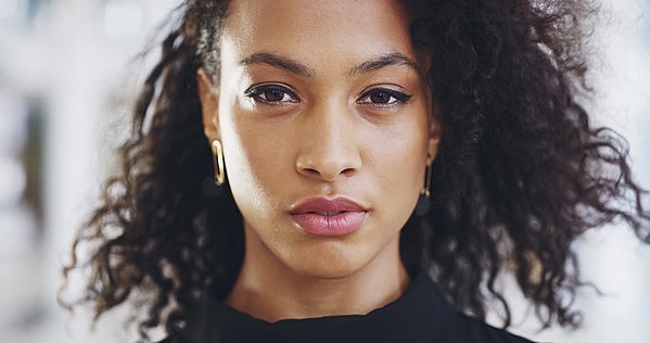Young woman with curly hair and serious expression