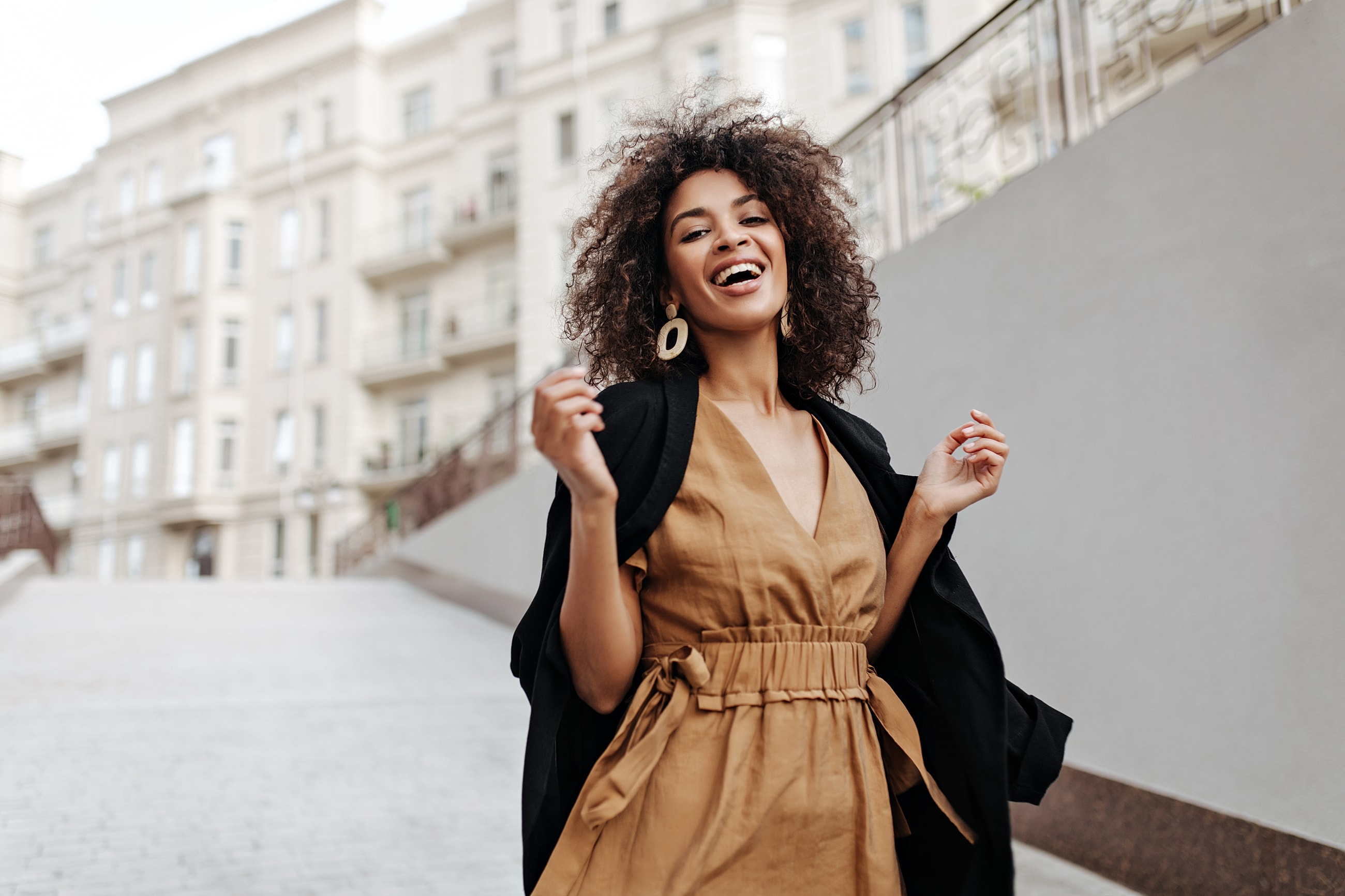 Smiling woman in stylish dress outdoors.