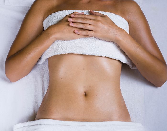 Person relaxing on spa table with towel.
