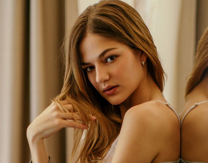 Young woman posing casually with long hair.